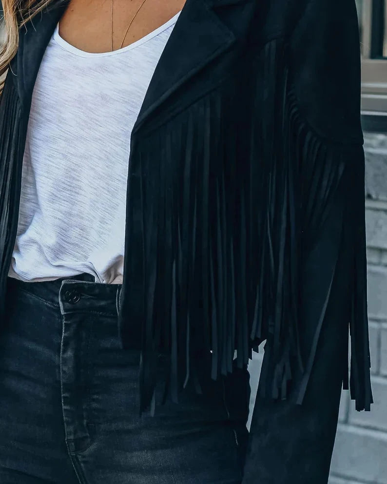 Zwart suède kwastenjasje gedragen over wit topje en zwarte jeans | Boutique Moda