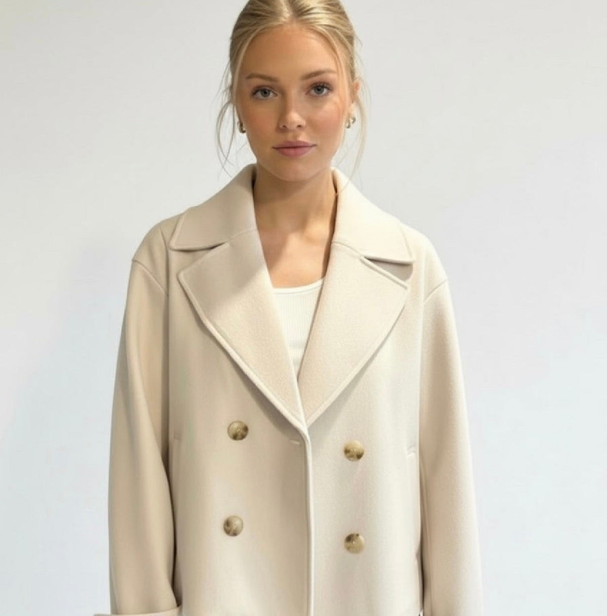 Lumina Wear Maya cropped double-breasted trench coat with structured shoulders, shown on model with neutral background.
