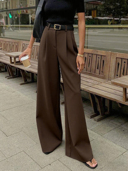 Female model displaying full-length pants on a plain background.