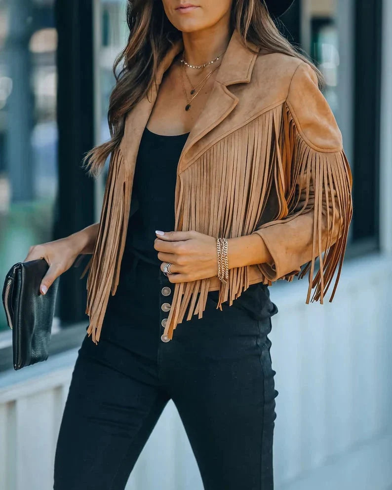 Vrouw draagt beige suède kwastenjasje met zwarte top en jeans | Boutique Moda