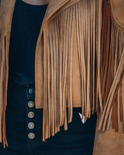 Bruin suède kwastenjasje gedragen over zwarte jurk, close-up detail | Boutique Moda