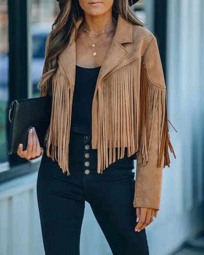 Beige suède jasje met franjes, gedragen door vrouw met zwarte clutch | Boutique Moda
