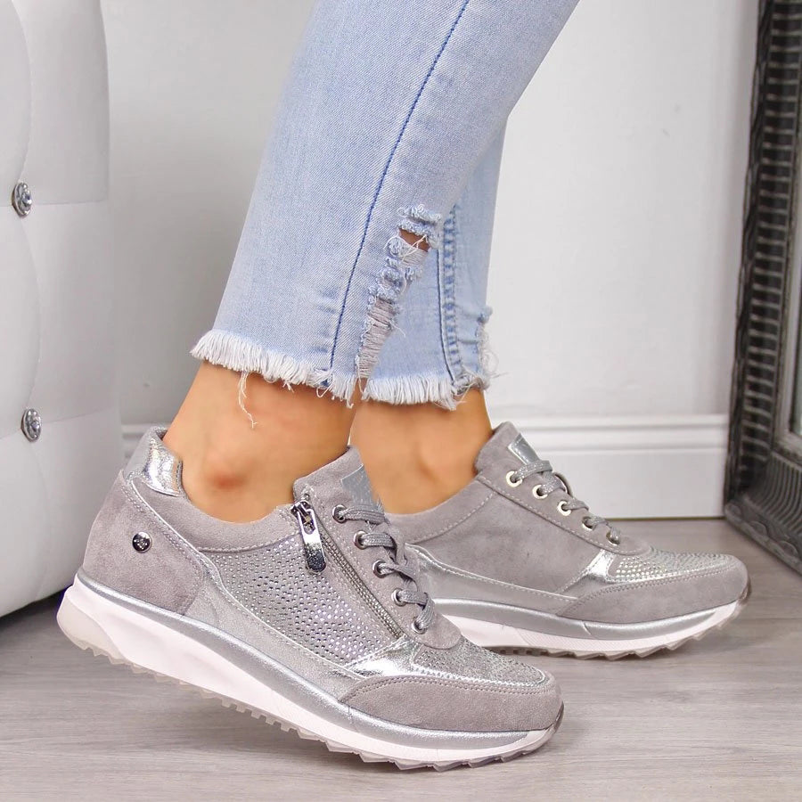 Jeans déchirés et baskets grises brillantes pour femme, style décontracté, mode urbaine, tendance chaussures 2023, sol en bois clair.