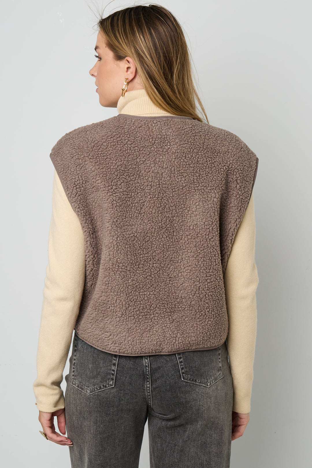Bruin fleece teddyvest gedragen door vrouw, achteraanzicht met beige coltrui | Boutique Moda