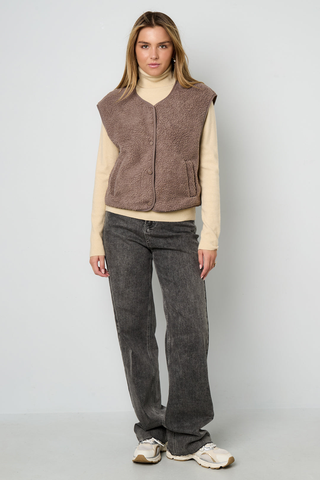 Bruin fleece teddyvest gedragen door vrouw met beige trui en jeans | Boutique Moda