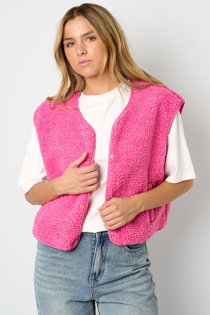 Roze teddy vest, mouwloos, gedragen door vrouw met witte top | Boutique Moda