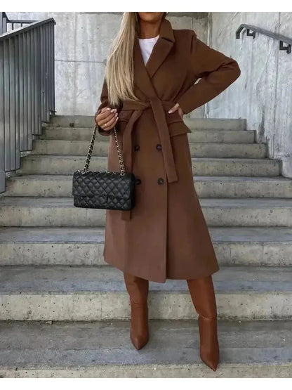 Beige Lumina Wear Kim double-breasted wool coat with elegant tailored design, shown hanging on a wooden background.