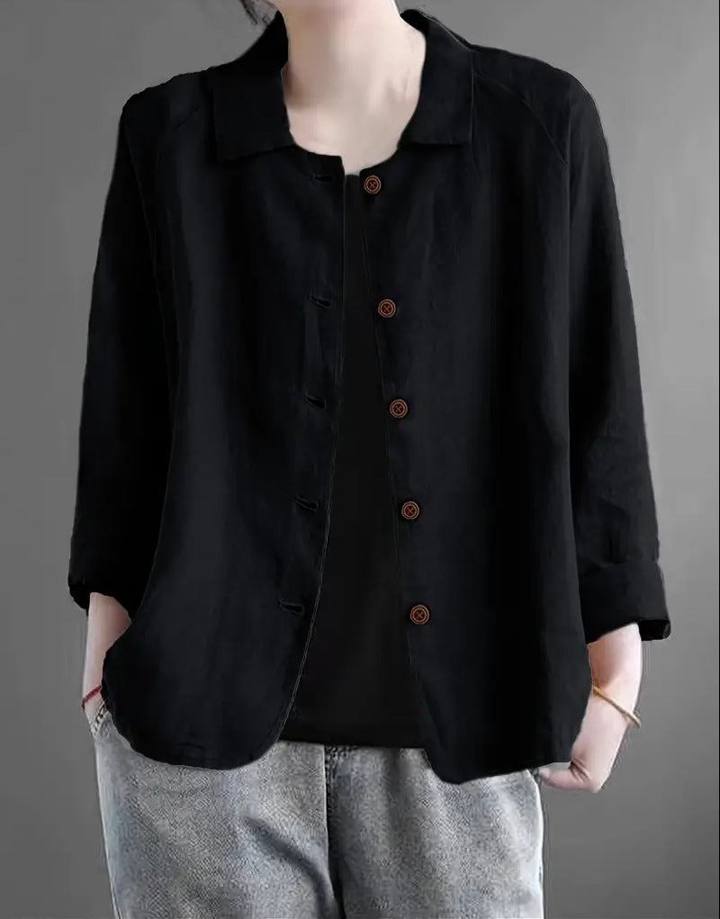 Person wearing a black button-up shirt with a gray background